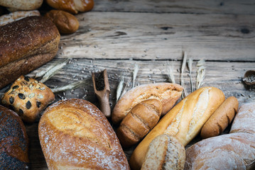 Assortment of baked bread on wooden rustic table background