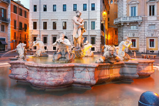 Fontana del Moro with four Tritons sculpted on the famous Piazza Navona Square during morning blue hour, Rome, Italy.