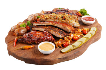 Meat grilled ribs on a white background, on a board with baked potatoes, cucumbers and pickled mushrooms