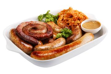 Sausage on a white plate with stewed cabbage and mustard