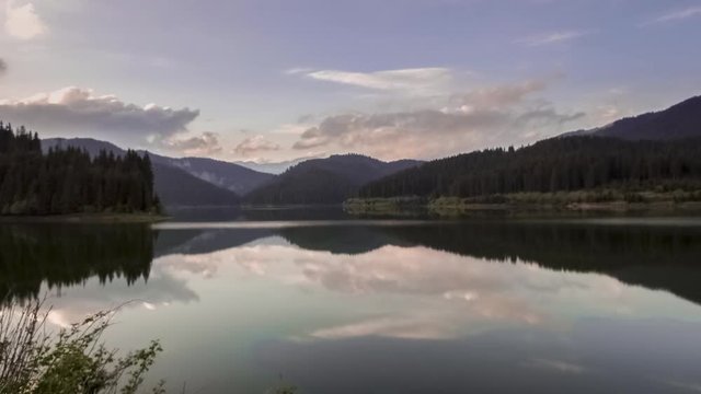Time lapse of sunset over mountain lake in summer
