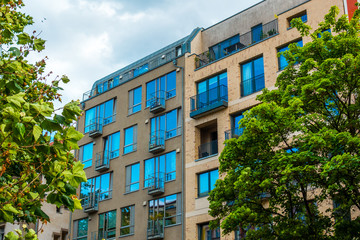Obraz na płótnie Canvas grey and orange modern apartment buildings with green trees