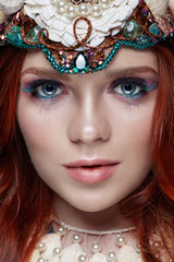 Redhead girl with bright makeup and big lashes. Mysterious fairy woman with red hair. Big eyes and colored shadows, long lashes. Sexy look, pure skin care, care face