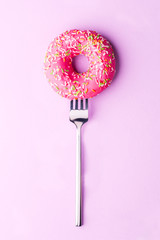 One pink donut on fork