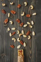 Healthy bar with nuts and seeds on the wooden background, top view