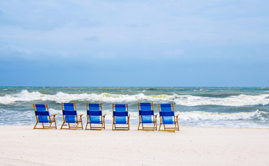 Beach chairs on white sand of a tropical beach. Scenic travel destination location for relaxation and recreation. 