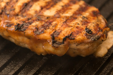 preparing chicken breast on a pan grill closeup