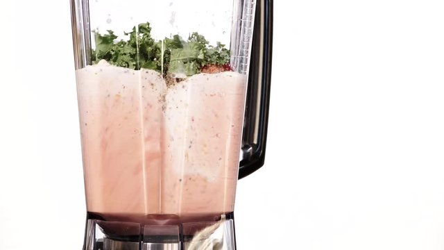 Making fresh mango strawberry fruit shake milkshake in blender high speed machine, on white. Healthy eating, vegetarian food, diet concept. 4K ProRes HQ codec