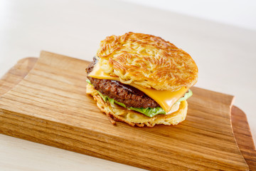 Ramen burger with beef and salad on a wooden desk. Top view