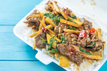 Rice topped with stir-fried beef and basil in a form box