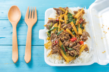 Rice topped with stir-fried beef and basil in a form box