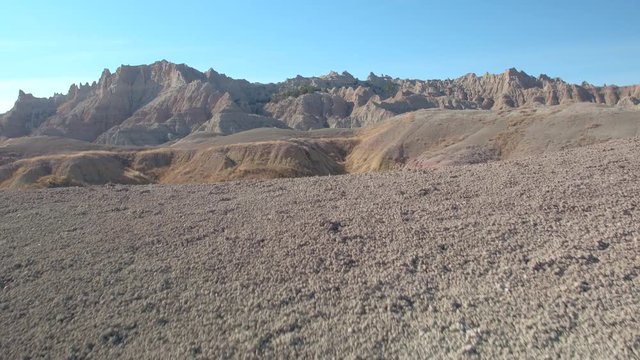 Beautiful endless sandstone formations and dry grass prairie at Badlands National Park in South Dakota. Stunning landscape with eroded rocky mountains rising out of vast grasslands in Great Plains