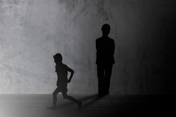 Silhouette Children run and play fun and learn in order to strengthen imagine casting a shadow engineer on a concrete wall. Learning and teaching concept