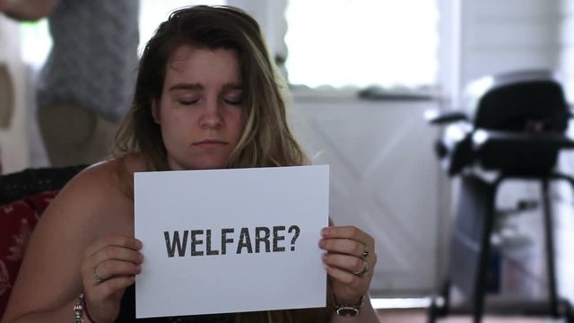 Frustrated woman holding up a welfare sign with question mark