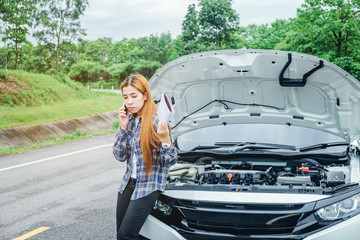 young Woman calling for assistance with his car broken down by the roadside