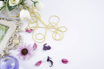 Perfume bottles with white rose flowers on light background. fragrance cosmetics, fragrance collection. Free space for text. Purple concept