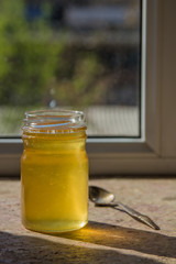 Organic pure honey in jar on window sill