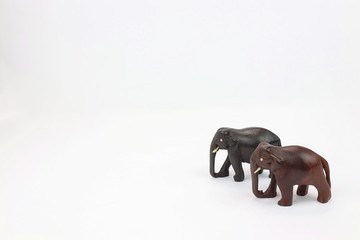 hand carved wooden elephants standing side by side isolated on white background 