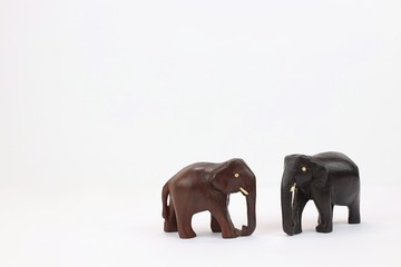 hand carved wooden elephants facing each other isolated on white background 