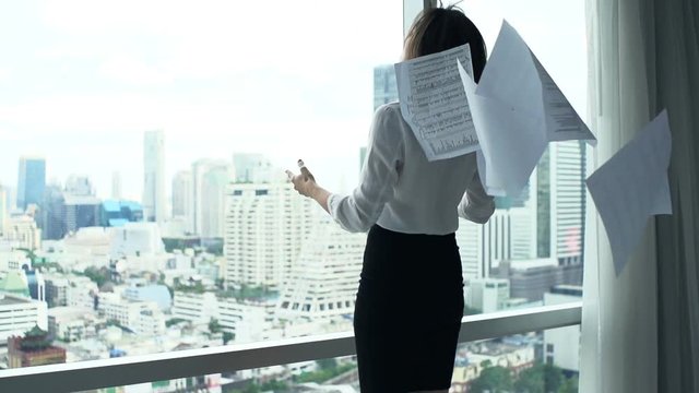 Overwhelmed businesswoman throwing documents in office, super slow motion 240fps
