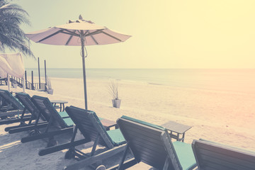 Fototapeta na wymiar sunbeds and sunshade, Umbrella beach chair on the beach. summer vacation concept. vintage filter color