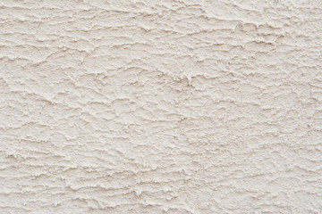 A wall with a rough surface is painted white