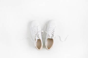 White female sneakers isolated on white background. Flat lay, top view