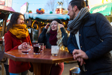 Freude treffen sich auf einem Weihnachtsmarkt und stoßen mit Glühwein an