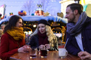 Freude treffen sich auf einem Weihnachtsmarkt und stoßen mit Glühwein an