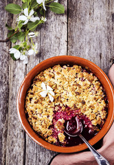 Cherry blackberry crumble with oatmeal crispy crust on vintage rustic wooden table. Healthy breakfast. Summer baking. Diet. Selective focus. Toned image 