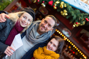 Freunde, Mann, Frau, Paar haben Spaß auf dem Weihnachtsmarkt, lachen, scherzen, trinken Glühwein mit Alkohol und freuen sich in Winterbekleidung