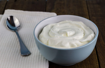 Natural creamy Greek yoghurt on wooden table