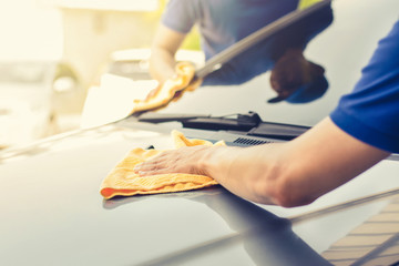 Auto service workers polishing car with microfiber cloth