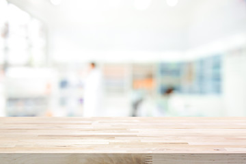 Empty wood counter top on blur pharmacy background