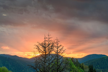 Fototapeta na wymiar Sun through stormy clouds - beautiful, breathtaking sunset over the mystical Rhodope mountains in Bulgaria, Europe
