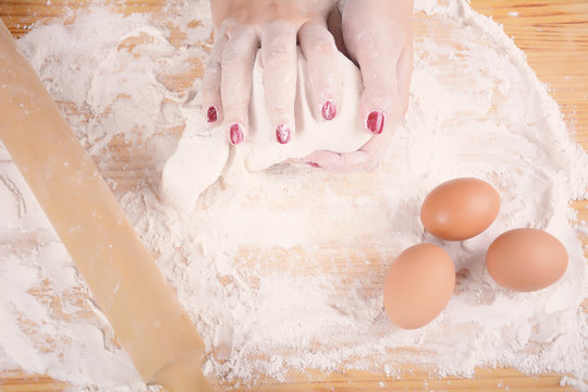 Woman hands kneading dough.