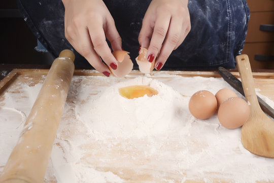 Woman breaking an egg.