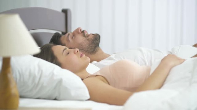 The man snore near the woman in the bed