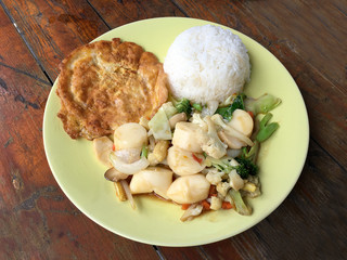 fried tofu with vegetables and Thai Omelette (scrambled eggs) in green dish on wooden table. Thai style Food. Vegetarian Food. vintage tone.