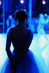 Silhouette of a ballerina standing behind the scenes of the theater