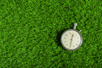 Silver chronometer on green grass