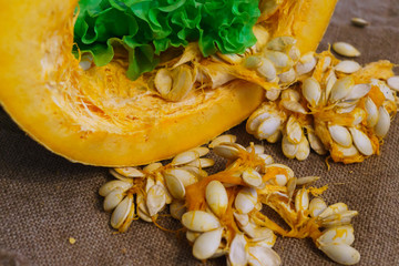 Pieces of yellow pumpkin together with seeds and greens.