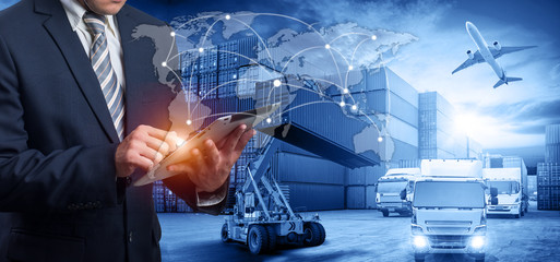 Hand holding tablet is pressing button on touch screen interface in front Logistics Industrial...