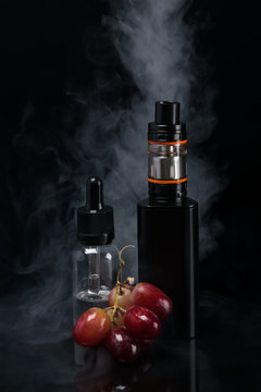 the concept of electronic cigarettes with grape on a background of smoke