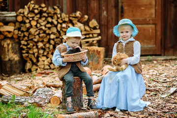 Naklejka na ściany i meble little boy and girl playing with rabbit in village