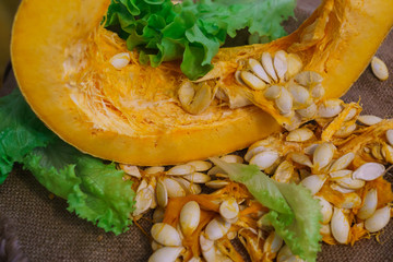 Pieces of yellow pumpkin together with seeds and greens.