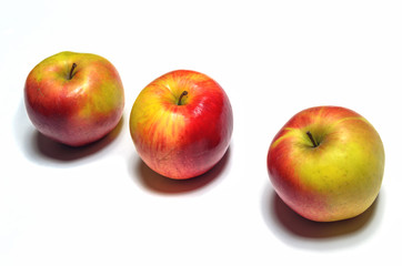 Three ripe apples on a white background
