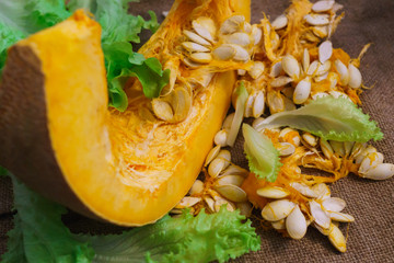 Pieces of yellow pumpkin together with seeds and greens.