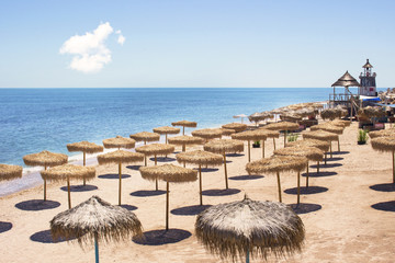 Top view of beach with straw umbrellas rows