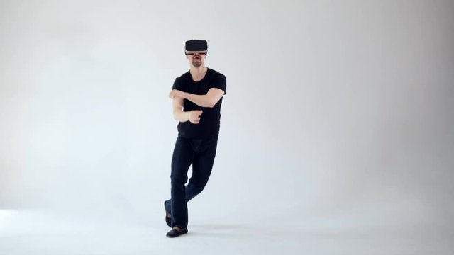 Young man wearing virtual reality headset and dancing.